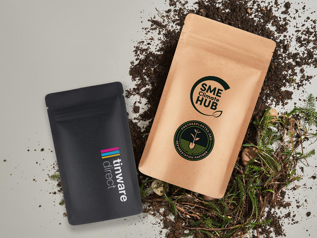 Sustainable Labeled Stand Up Pouch Packaging In Brown And Black resting on dirt with a white background. 