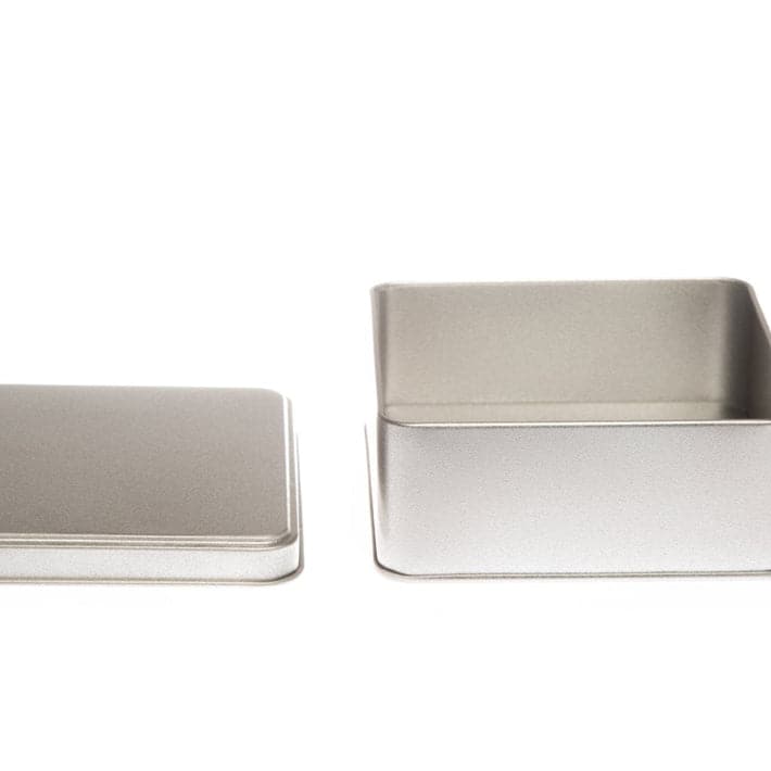 A square silver tin with its lid off to show the inside.