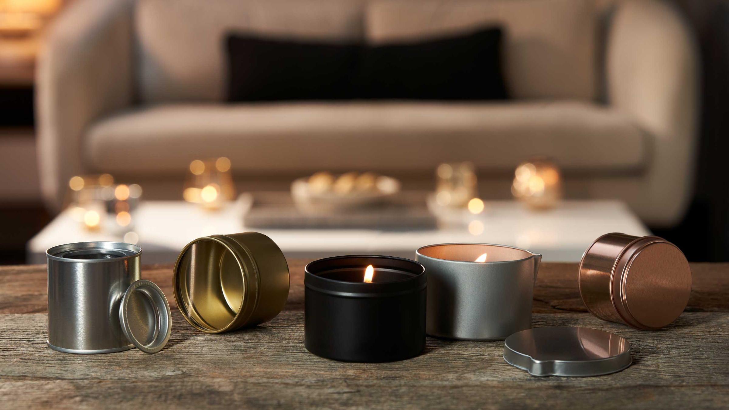 A collection of tins with candles lit inside in a lounge.