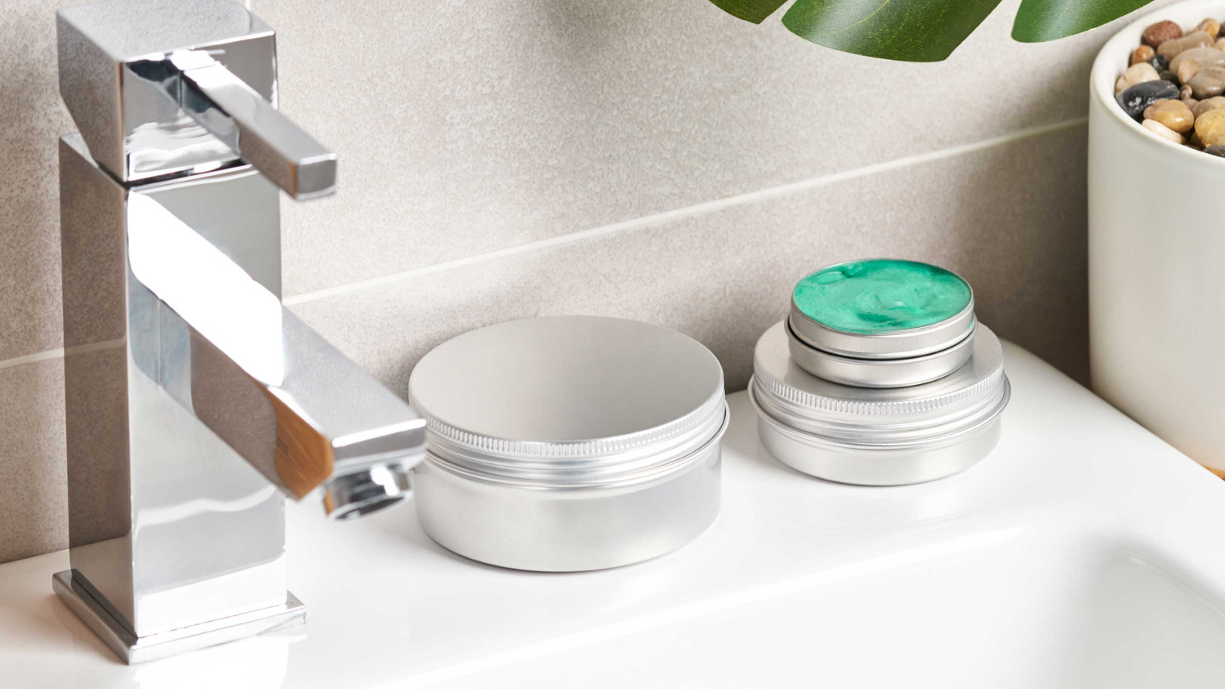 Aluminium packaging with cosmetics in on the side of a bath.