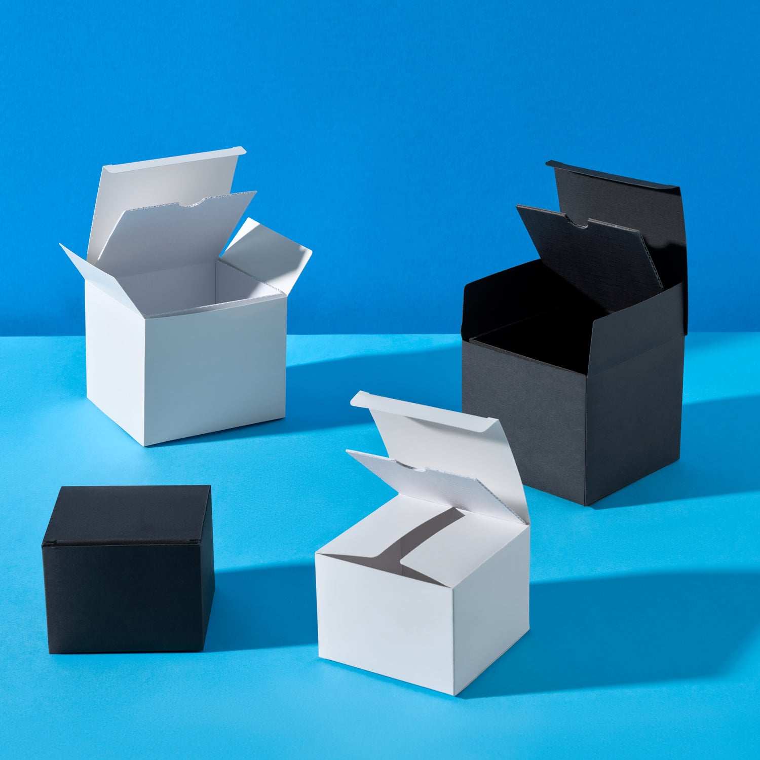 Four open boxes in black and white on a blue background