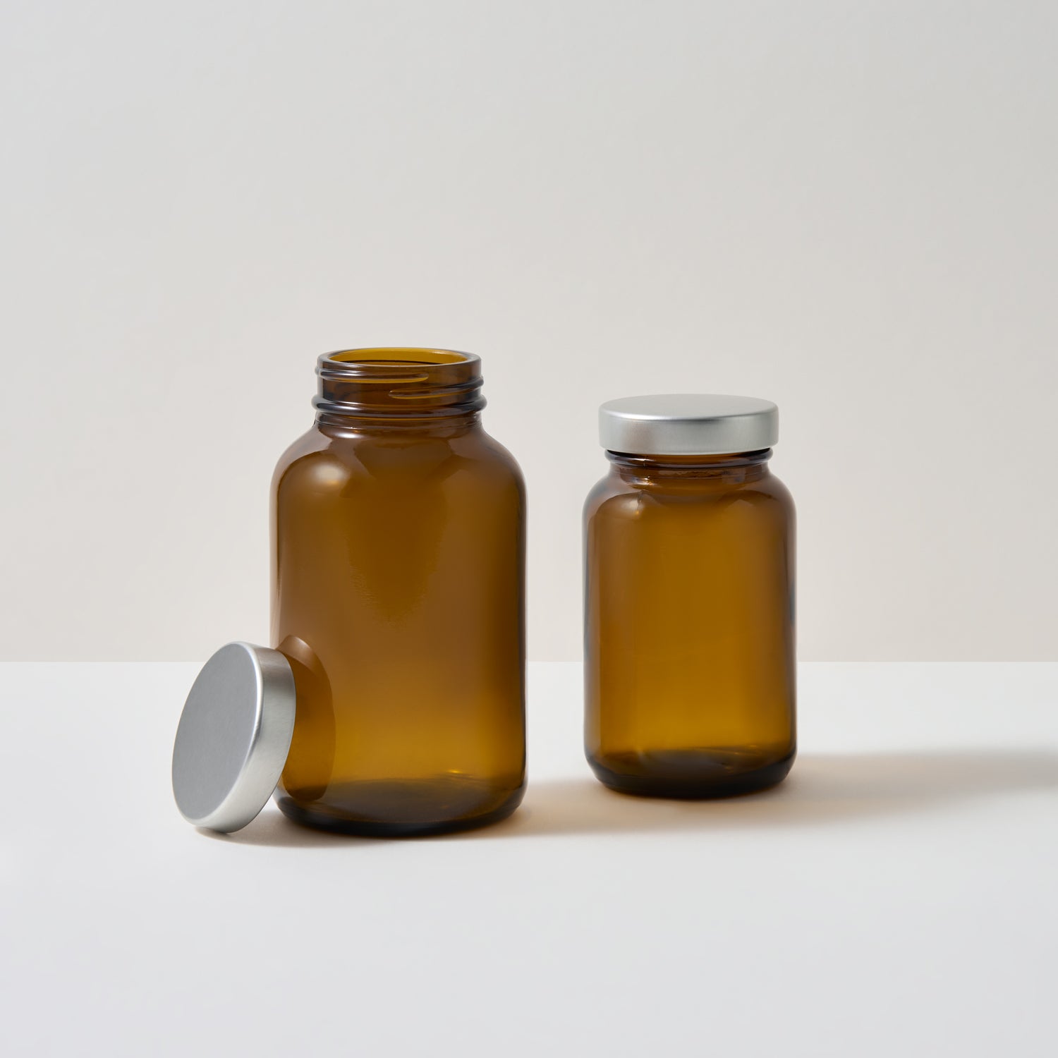Collection of amber glass supplements jars on white background. 