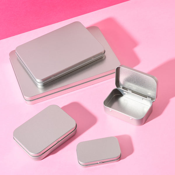 Flat tin packaging in various sizes on pink background.
