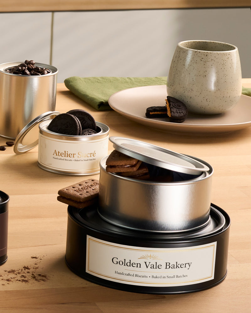 Labelled lever lid tins used for biscuits, cakes and coffee beans in a kitchen. 