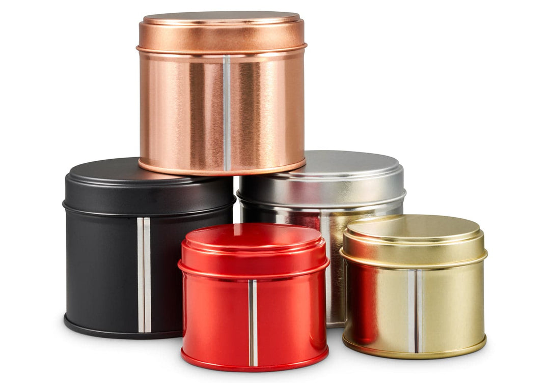 Three welded side seam tins in gold, silver, black, red and rose gold which shows the silver line in the colouration due to the welding.