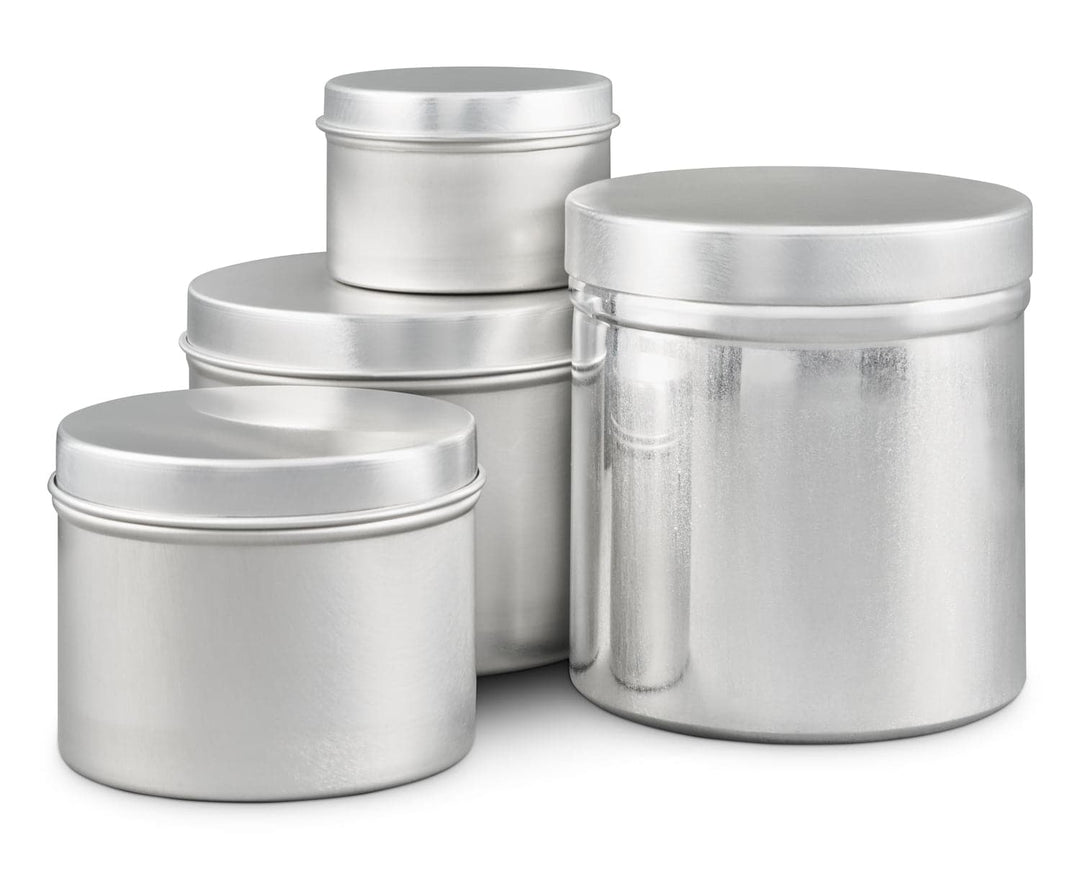 Collection of four round silver aluminum containers with lids on a white background
