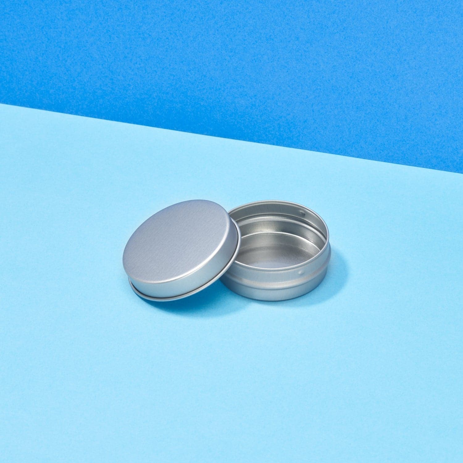 Silver lip balm tin showing lid pips and internal tin view.
