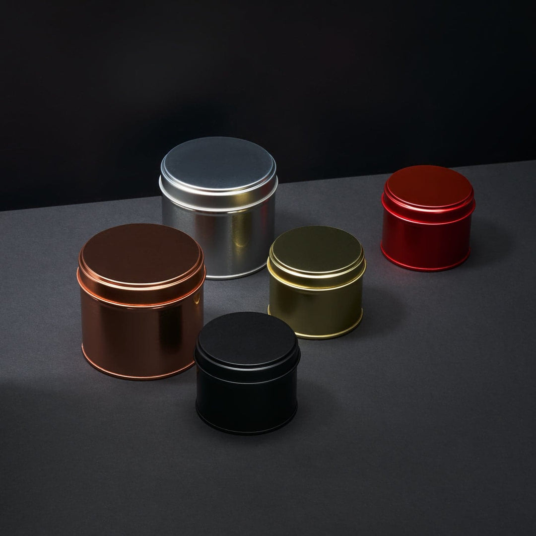 A collection of welded side seam tins in rose gold, silver, gold, red and black.
