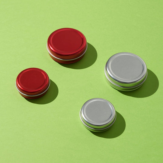 Four red and silver slip lid lip balm tins in two different sizes.