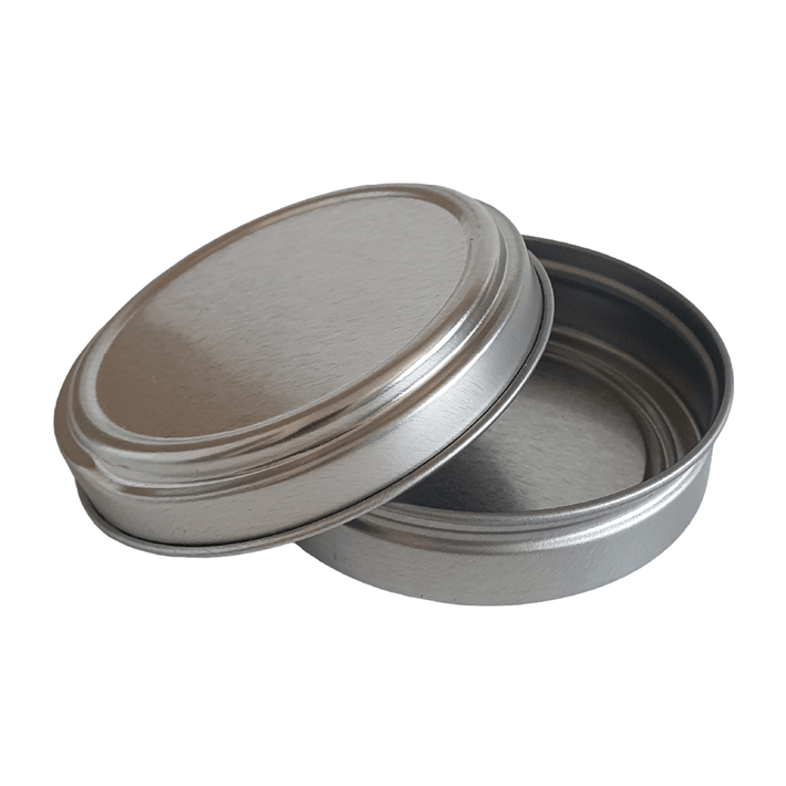 An open silver tin with push to open lid resting on the base.